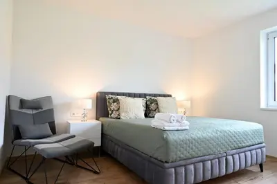 a bedroom with a bed and a chair with towels on it at Pool & Relax Mukařov in Srbín