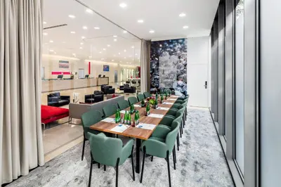 a dining room with a long table and green chairs at OREA Hotel Andels Depandance in Prague