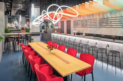 a restaurant with wooden tables and red chairs at OREA Hotel Andels Depandance in Prague