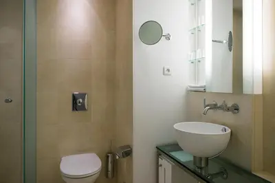 a bathroom with a toilet and a sink and a mirror at OREA Hotel Andels Depandance in Prague