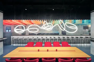 a conference room with a table and red chairs at OREA Hotel Andels Depandance in Prague
