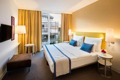 a hotel room with a large bed with blue pillows at OREA Hotel Andels Depandance in Prague