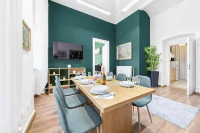 a dining room with a wooden table and blue chairs at Cozy Central Two-Bedroom Apartment in Prague