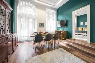 a dining room with green walls and a table and chairs at Cozy Central Two-Bedroom Apartment in Prague
