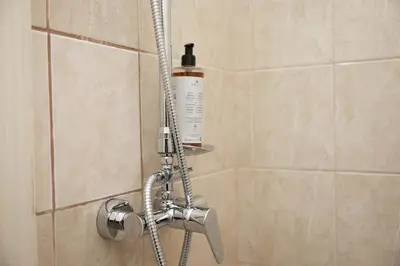 a shower with a bottle of shampoo in a shower stall at Cozy Central Two-Bedroom Apartment in Prague