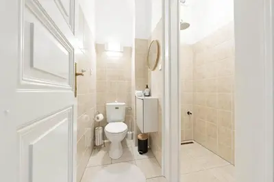a small bathroom with a toilet and a shower at Cozy Central Two-Bedroom Apartment in Prague