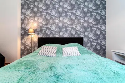 a bedroom with a green bed with two white pillows at Hound Deluxe Suite in Prague