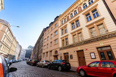 a city street with parked cars and buildings at Hound Deluxe Suite in Prague