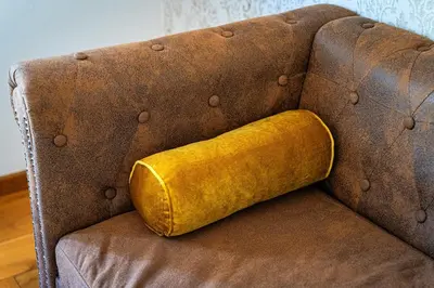 a yellow pillow sitting on a brown couch at Hound Deluxe Suite in Prague