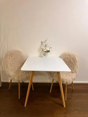 a white table with two chairs and a vase with flowers at Evas Cozy Studio Prague in Prague