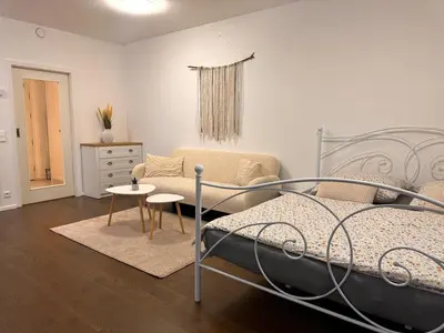 a bedroom with a bed and a couch and a table at Evas Cozy Studio Prague in Prague