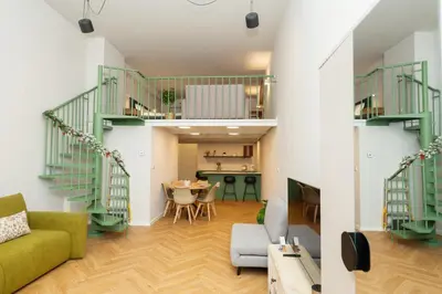 a living room with green stairs and a dining room at Prague City Center 99m2 Andel Family Apartment for 6 Bath and Shower Self Check in in Prague