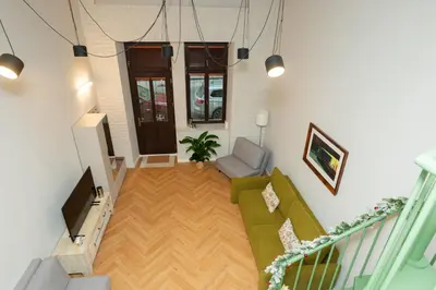 a living room with a green couch and a chair at Prague City Center 99m2 Andel Family Apartment for 6 Bath and Shower Self Check in in Prague