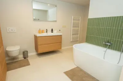 a bathroom with a tub and a sink and a toilet at Prague City Center 99m2 Andel Family Apartment for 6 Bath and Shower Self Check in in Prague