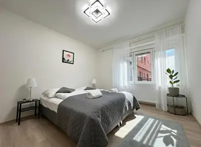 a white bedroom with a bed and a window at Spacious 3BR Apartment near Metro in Prague