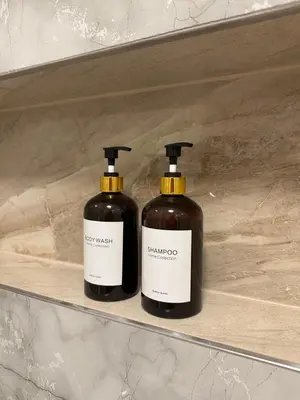 two bottles of soap are sitting on a shelf at Spacious 3BR Apartment near Metro in Prague