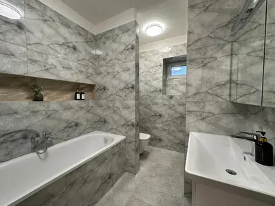 a bathroom with a tub and a sink at Spacious 3BR Apartment near Metro in Prague