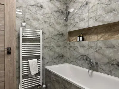 a bathroom with a bath tub and a sink at Spacious 3BR Apartment near Metro in Prague