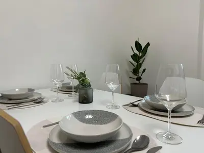 a white table with plates and wine glasses on it at Spacious 3BR Apartment near Metro in Prague