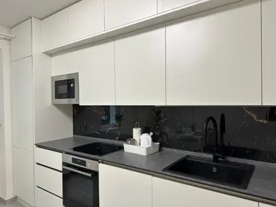 a white kitchen with a sink and a microwave at Spacious 3BR Apartment near Metro in Prague