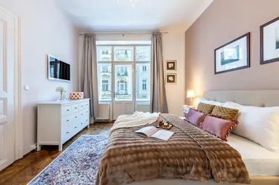 a bedroom with a large bed and a window at Prague Days - Two Bedroom Apartment next to Dancing House with High-Speed WiFi in Prague