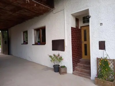 a white building with a door and a potted plant at Ubytováni U rybníčku in Bzová