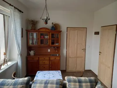 a living room with a cabinet and a couch at Ubytováni U rybníčku in Bzová