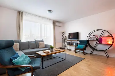 a living room with a couch and two chairs at Cosy Parkside Apartment Prague in Prague