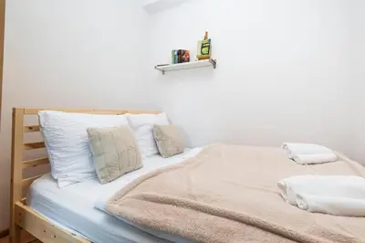 a bed with a striped pillow in a bedroom at Cosy Parkside Apartment Prague in Prague