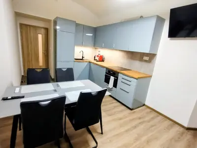 a kitchen with a table and chairs in a room at 2 - room apartment with terrace and free parking in Prague