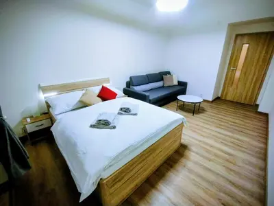 a bedroom with a large bed and a couch at 2 - room apartment with terrace and free parking in Prague