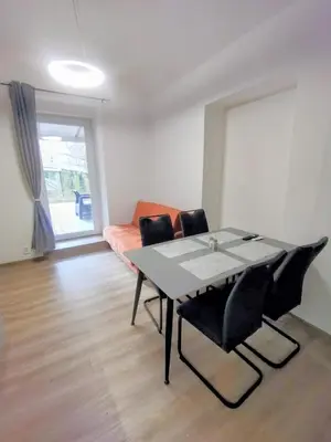 a dining room with a table and chairs and a couch at 2 - room apartment with terrace and free parking in Prague