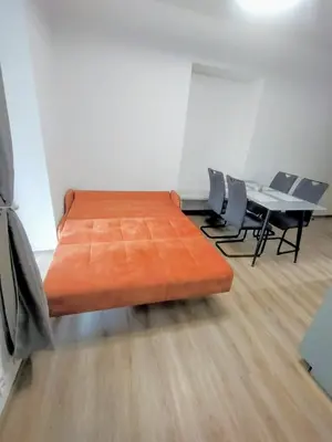 a bed in a room with a table and chairs at 2 - room apartment with terrace and free parking in Prague