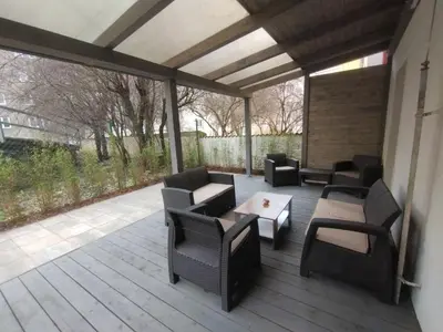 a covered deck with chairs and tables and a table at 2 - room apartment with terrace and free parking in Prague