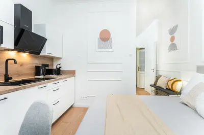 a kitchen with white cabinets and a counter top at Rentero Central Apartment near Charles Square in Prague