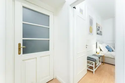 a white door leading to a bedroom with a bed at Rentero Central Apartment near Charles Square in Prague