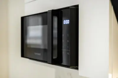 a microwave oven on a shelf on a wall at Rentero Central Apartment near Charles Square in Prague