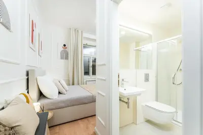 a bathroom with a bed and a toilet and a sink at Rentero Central Apartment near Charles Square in Prague
