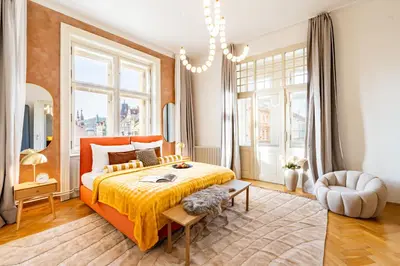 a bedroom with an orange bed and a large window at Prague Days - Four Bedroom Apartment with Workspace and 250Mbs WiFi in New Town in Prague