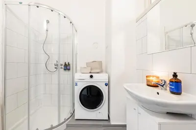 a washing machine in a bathroom next to a sink at Prague Days - Four Bedroom Apartment with Workspace and 250Mbs WiFi in New Town in Prague