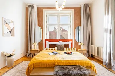 a bedroom with a large bed with a yellow bedspread at Prague Days - Four Bedroom Apartment with Workspace and 250Mbs WiFi in New Town in Prague