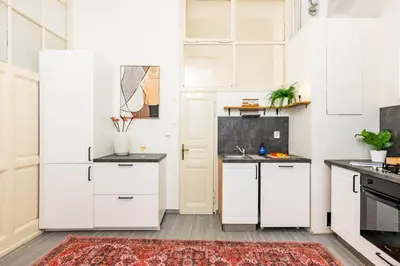 a kitchen with white cabinets and a red rug at Prague Days - Four Bedroom Apartment with Workspace and 250Mbs WiFi in New Town in Prague