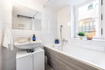 a white bathroom with a sink and a bath tub at Prague Days - Four Bedroom Apartment with Workspace and 250Mbs WiFi in New Town in Prague