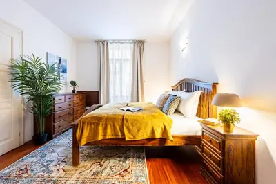 a bedroom with a bed with a yellow blanket on it at Prague Days - Three Bedroom Apartment with AC, Desk and 100Mbs WiFi in New Town in Prague