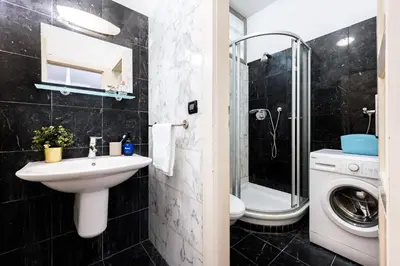 a bathroom with a sink and a washing machine at Prague Days - Three Bedroom Apartment with AC, Desk and 100Mbs WiFi in New Town in Prague