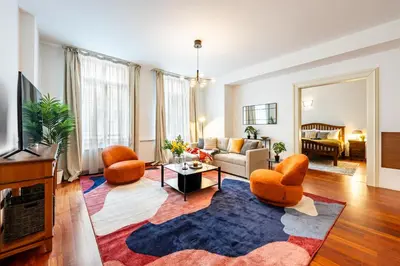 a living room with a couch and chairs and a tv at Prague Days - Three Bedroom Apartment with AC, Desk and 100Mbs WiFi in New Town in Prague