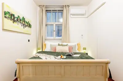 a bedroom with a large bed with a window at Prague Days - Three Bedroom Apartment with AC, Desk and 100Mbs WiFi in New Town in Prague