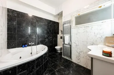 a bathroom with a tub and a toilet at Prague Days - Three Bedroom Apartment with AC, Desk and 100Mbs WiFi in New Town in Prague