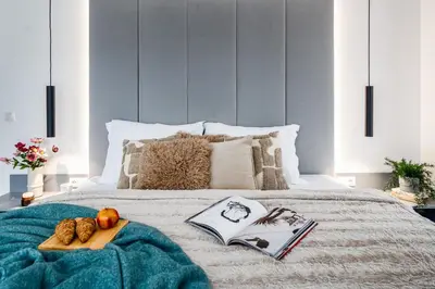 a bed with a tray of fruit and a book at Prague Days - Two Bedroom Apartment with Garage, AC, Terrace and Balcony in Vinohrady in Prague