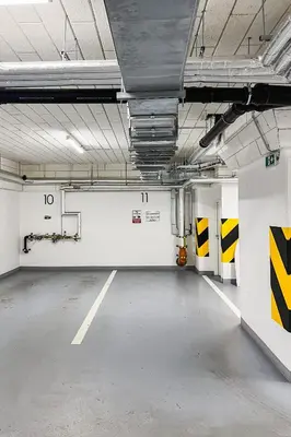 an empty parking garage with yellow and white walls at Prague Days - Two Bedroom Apartment with Garage, AC, Terrace and Balcony in Vinohrady in Prague